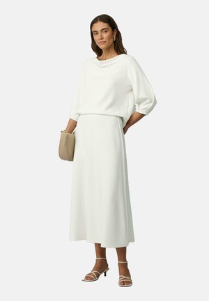 Abbigliamento bianco a due pezzi composto da un top lungo a maniche lunghe e una gonna lunga. Tessuto morbido con una vestibilità comoda e dettagli di drappeggio sottili.