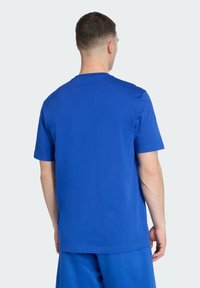 Solid blue T-shirt with a crew neck and short sleeves, made from cotton. Smooth texture and relaxed fit, with no visible patterns or accents.