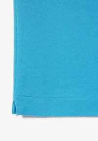 Sininen kankainen tekstiili, jossa on teksturoitu kudos, huoliteltu reuna ja sivuhaarukkayksityiskohtia, jotka osoittavat sileää viimeistelyä ja kestävää rakennetta.