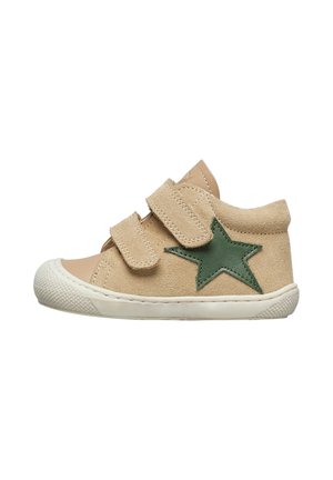 Baskets en daim beige avec une applique en étoile verte, deux bandes Velcro, semelle en caoutchouc blanche, bout arrondi et motifs texturés sur la semelle.