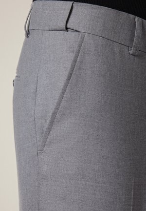 Szare spodnie garniturowe o gładkiej fakturze, z płaskim przodem, bocznymi kieszeniami i dopasowanym krojem, wycięte na wysokości bioder.