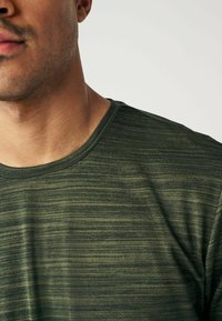 Mørkegrøn t-shirt med et struktureret, stribet design. Har en rund halsudskæring og korte ærmer, lavet af et let, åndbart stof.