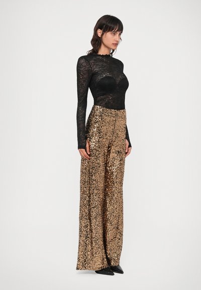 Must mustriga pikka varrukaga bodi, millele on lisatud kõrge vöökohaga kuldsetest seqvinatest laiade jalgadega püksid. Sile tekstuur koos läikega; stiilne siluett.