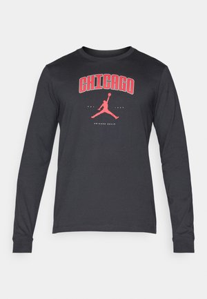 Camisola de manga longa preta feita de algodão, com um decote redondo. Apresenta uma grafica vermelha de "Chicago" e um ícone de uma figura a saltar.