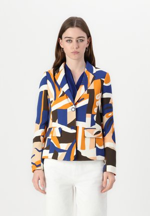 Kleurige patroon blazer in oranje, blauw en crème, met scherpe revers, twee voorkruiken en een getailleerde snit. Gepaard met een blauwe blouse.