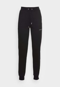 Svarta sweatpants i mjukt material, med dragsko i midjan, muddade anklar och en liten logodetalj på vänster lår.