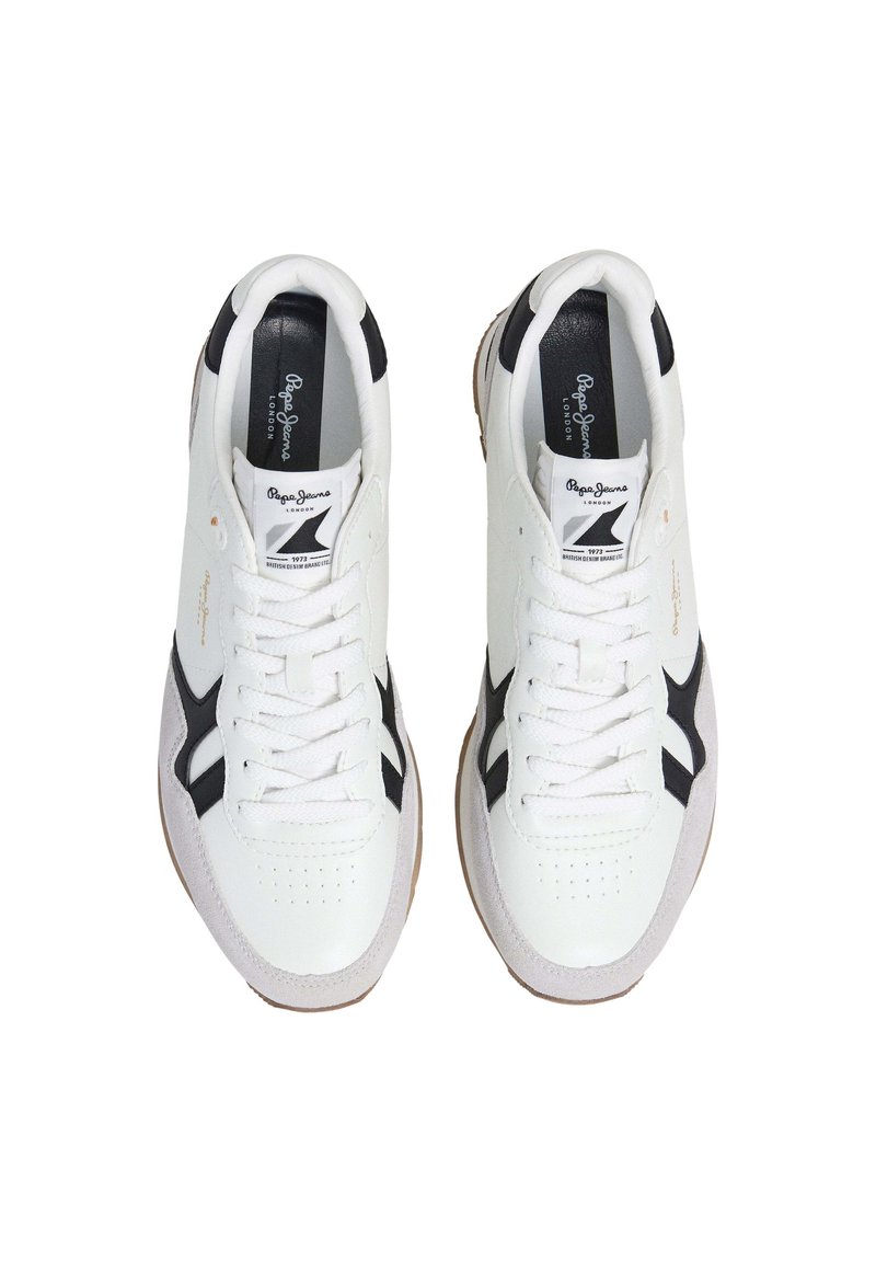 Zapatillas deportivas blancas con detalles en negro, materiales de cuero y ante, área del dedo del pie perforada y suela de goma. Marca en la lengüeta y el costado.