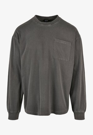 Hosszú ujjú sötétszürke pamut póló, kerek nyakú és mellzsebes. Bordás mandzsettákkal és laza fittedel rendelkezik.