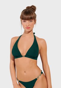 Bikini w kolorze turkusowym, składający się z bluzki na halter z trójkątnym wzorem oraz złotymi akcentami, w połączeniu z pasującymi do niej majtkami.