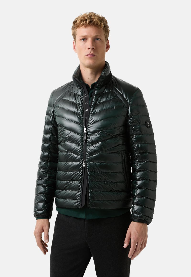 Zelená prošívaná bunda s zipem, prošívaným designem a stojáčkem. Obsahuje boční kapsy a nášivku s logem na rukávu.