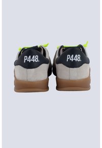 Sneaker in suede con dettagli neri sul tallone, lacci verdi e un logo bianco ben visibile sul retro. Suole in gomma con una finitura texturizzata.