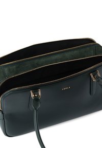 Πράσινη δερμάτινη τσάντα χειρός με δομημένο σχέδιο, που διαθέτει πολλαπλές θήκες με φερμουάρ, χρυσά μεταλλικά στοιχεία και ανάγλυφη λεπτομέρεια λογότυπου.