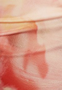 Miękka, rozciągliwa tkanina w odcieniach brzoskwiniowym, różowym i jasnopomarańczowym, z delikatnym wzorem akwarelowym i gładką teksturą.