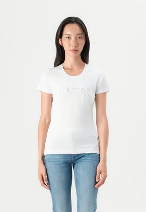 T-shirt blanc à manches courtes avec logo brodé "Guess est. 1981" sur le devant. Tissu en coton doux avec un design ajusté.