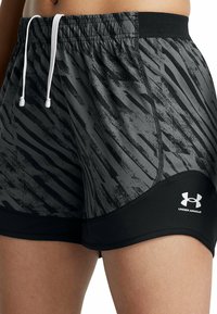 Svarta och grå sportshorts med randigt mönster, elastisk midja, vit dragsko och svart nätfoder. Under Armour-logotypen visas.