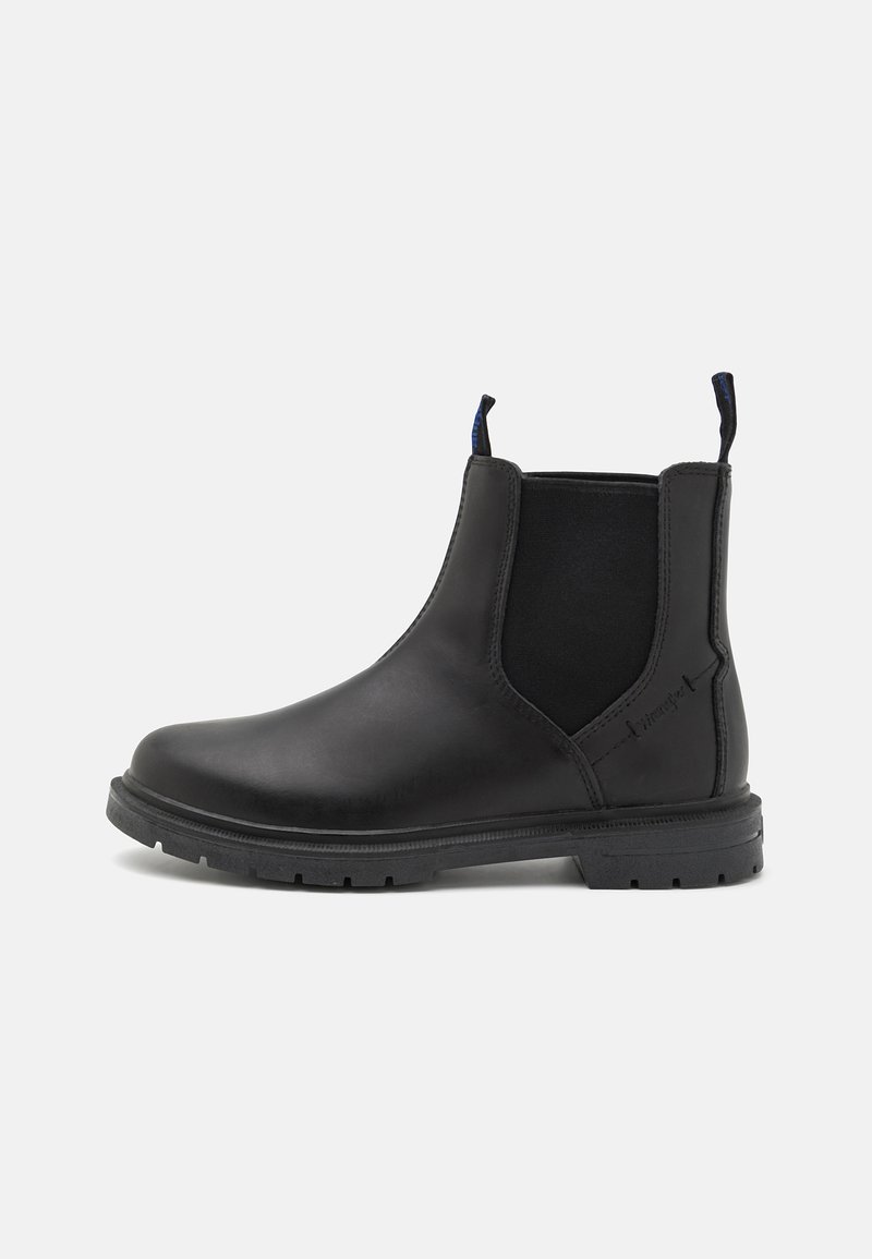 Botas Chelsea de cuero negro con paneles laterales elásticos, suela de goma gruesa y talón reforzado. Presenta tiradores para facilitar su uso.