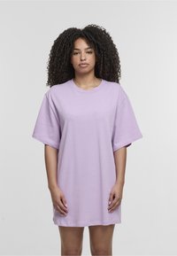 Jasnofioletowa, oversize sukienka-tshirt, wykonana z bawełny, z krótkimi rękawami, okrągłym dekoltem, gładką teksturą, do kolan, o minimalistycznym designie.