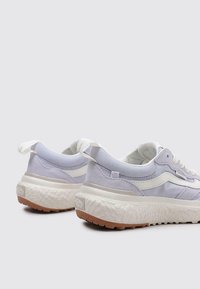 Sneaker di un leggero viola con suola bianca testurizzata e dettagli in gomma naturale. Presentano materiali in tela e suede con un design arrotondato.
