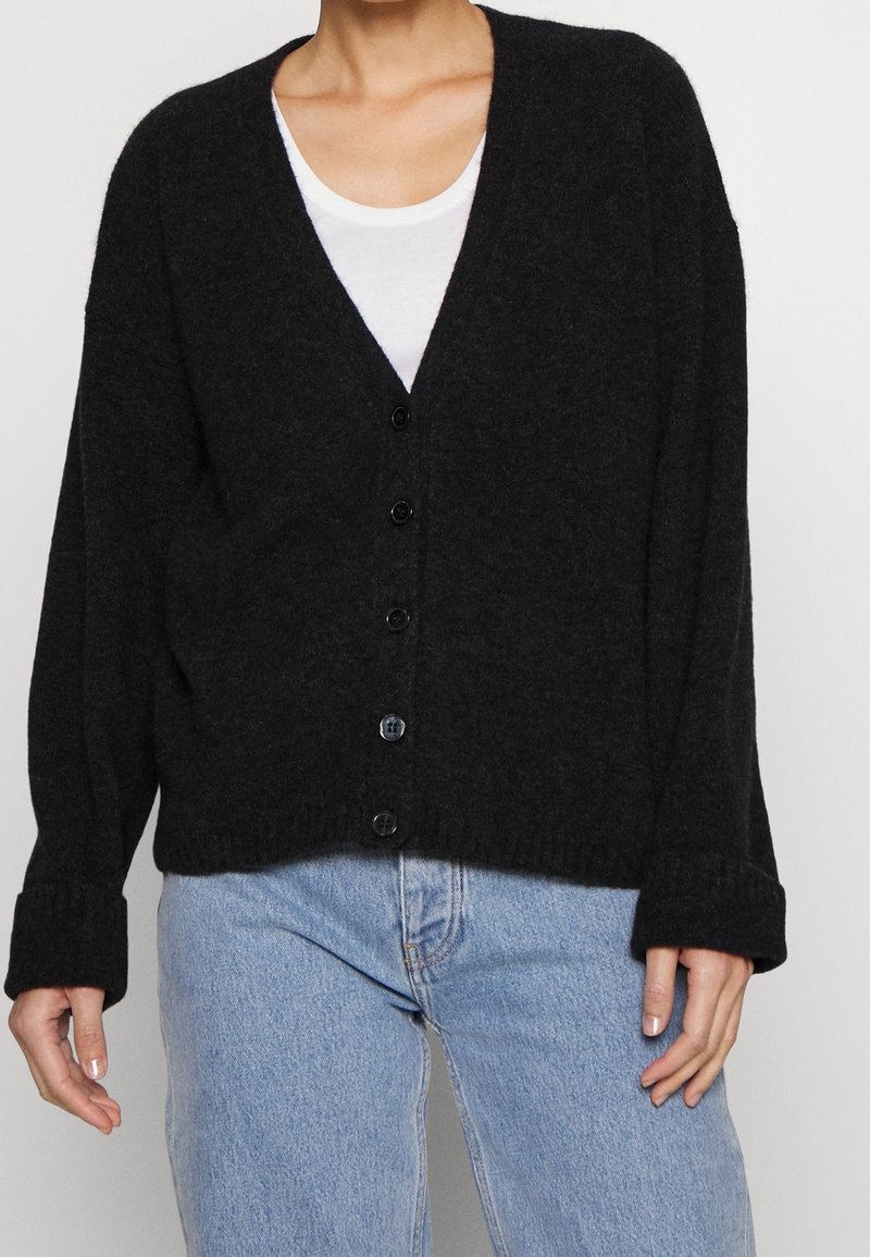 Czarny kardigan wykonany z miękkiego, teksturowanego materiału, z głębokim dekoltem w serek, sześcioma guzikami z przodu oraz ściągaczami na rękawach i na dole.