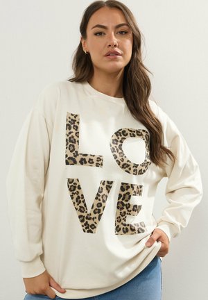 Sudadera crema con grande texto "LOVE" en estampado de leopardo. Cuenta con mangas largas, un cuello redondo y un corte relajado. Textura de tela suave.