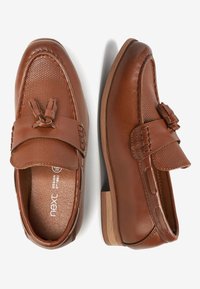 Chaussures en cuir marron avec une boîte à orteils texturée, détail de nœud décoratif et talon en bois. Fini lisse et conception à enfiler.