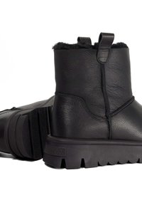 Black leather ankle boots with textured finish, fleece lining, and a rugged rubber sole featuring a jagged tread pattern.