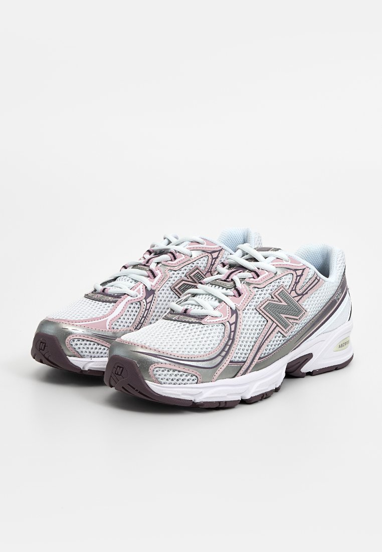 Sportliche Schuhe mit einem Obermaterial aus Mesh in Weiß, akzentuiert mit rosa und grauen Details. Runde Zehenpartie, Schnürsenkel und Gummisohle. Auffälliges Dämpfungselement.