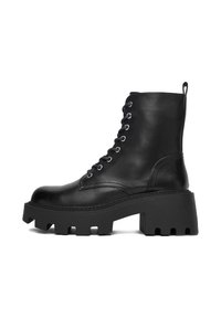 Czarne skórzane botki za kostkę z grubą podeszwą, okrąg�łym noskiem, sznurowanym przodem i pętelką z tyłu. Dekoracyjne przeszycia wzdłuż szwów.
