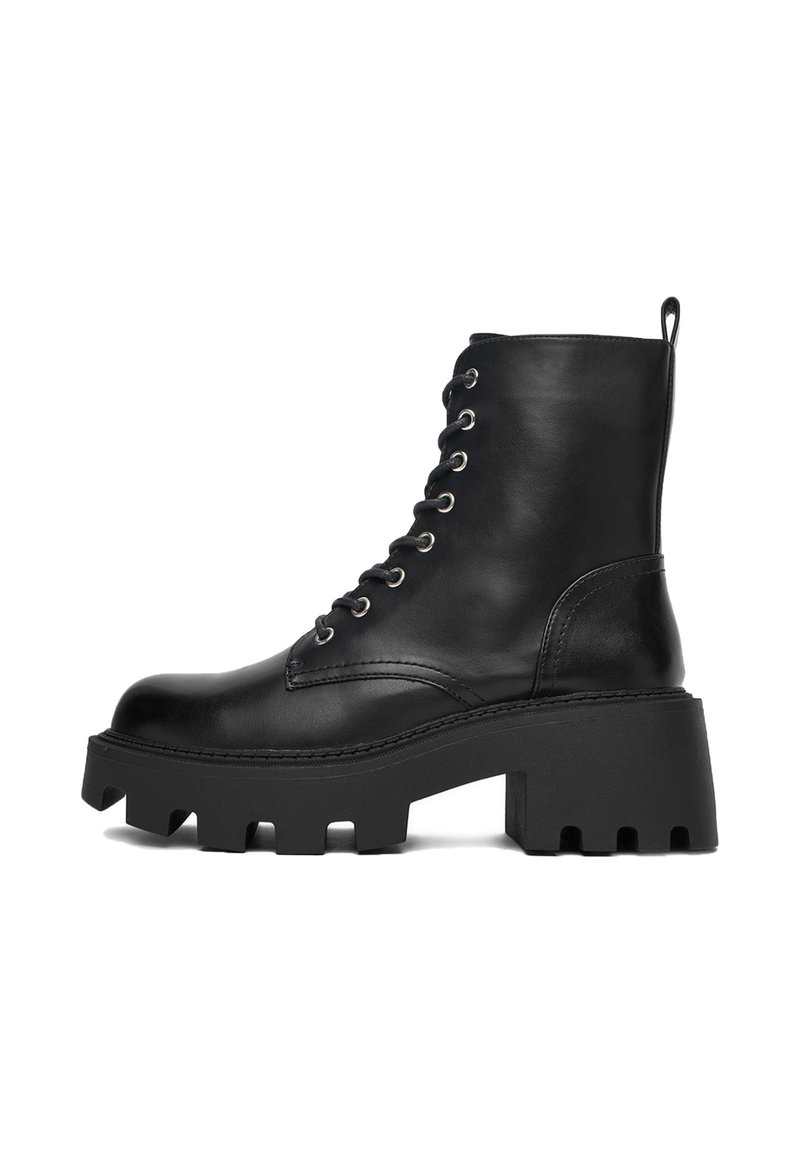 Czarne skórzane botki za kostkę z grubą podeszwą, okrągłym noskiem, sznurowanym przodem i pętelką z tyłu. Dekoracyjne przeszycia wzdłuż szwów.