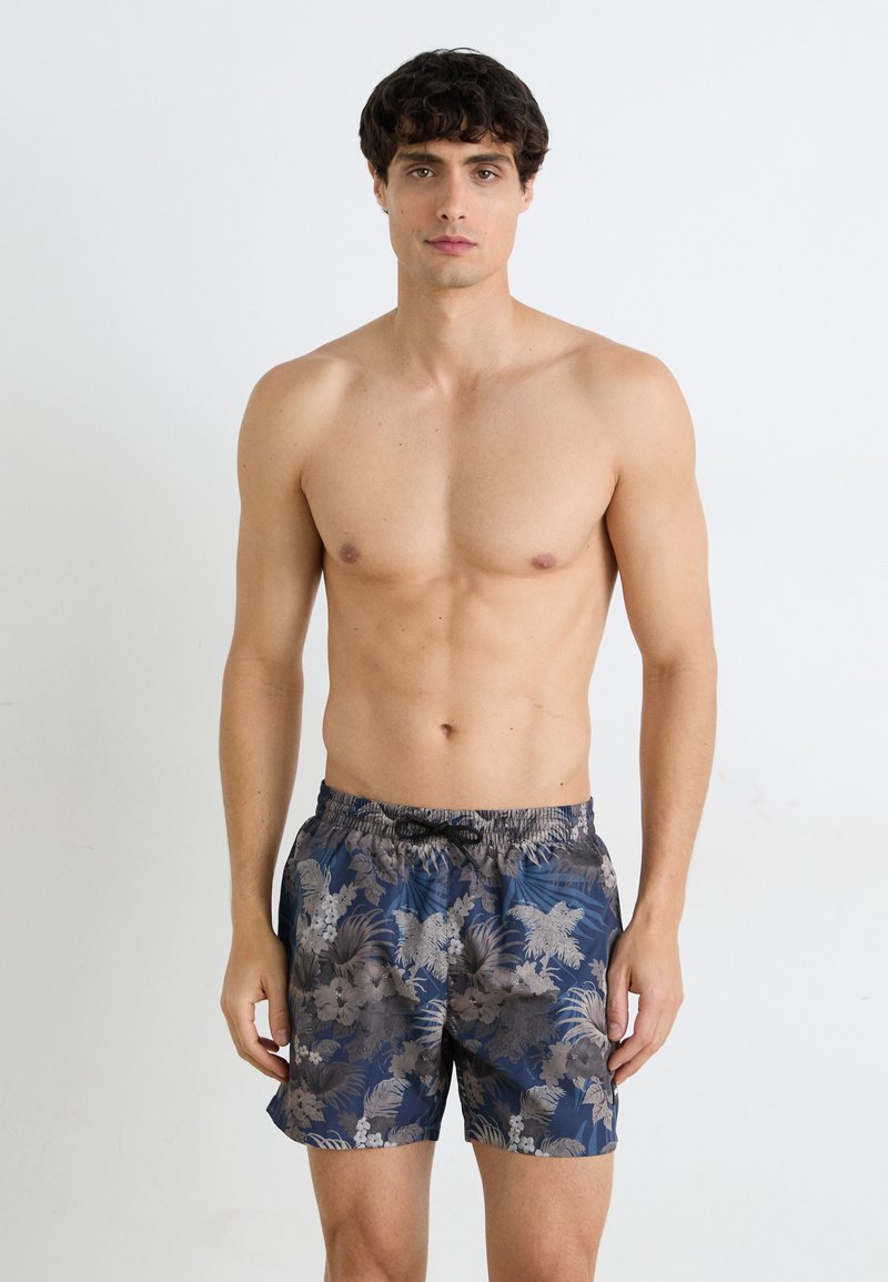 Pantaloni de baie pentru bărbați, de culoare albastră închis, cu un model floral tropical în nuanțe de gri și bej. Dispune de un brâu elastic și buzunare laterale.