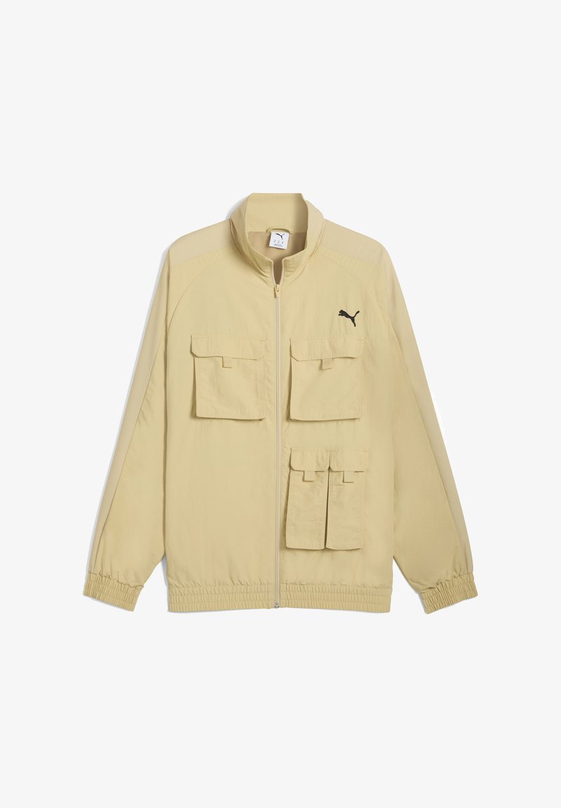 Lys gul jakke med lynlås foran og flere lommer, med et sort Puma-logo på venstre bryst.