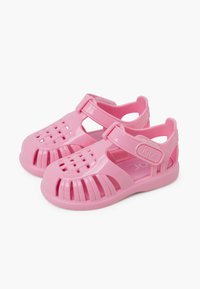 Roze plastic sandalen met een gesloten neus, uitsnijdingen in het ontwerp en een verstelbare band met klittenbandsluiting. Lichtgewicht en gladde textuur.