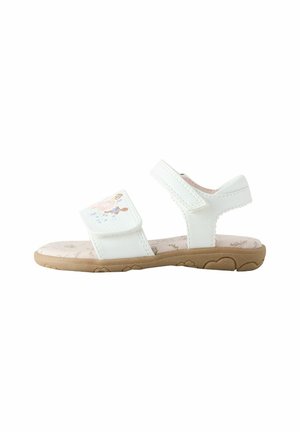 White toddler sandal with adjustable straps, floral embroidery on front strap, and tan rubber sole with heart patterns.