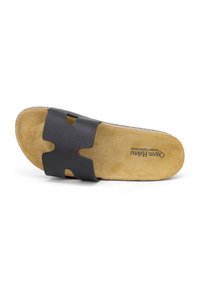Infradito in pelle nera con design a tagli, dotato di una soletta in suede beige e suola in gomma naturale. Punta arrotondata e suola piatta.