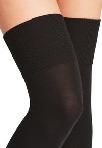 Meias pretas até à coxa com cós canelado e parte da perna transparente, textura lisa e design sem costuras.