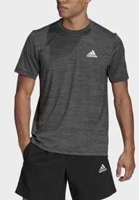 Svart kortärmad sportt-shirt med melerad textur och en vit Adidas-logotyp på vänster bröst.