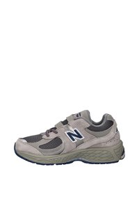 Baskets New Balance grises et noires avec des panneaux en mesh et en daim, double fermeture velcro, et semelle épaisse texturée vues de profil.