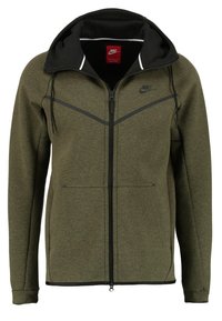 Olivgrön zip-up sweatshirt med svarta detaljer, har en huva, texturerat tyg och en Nike-logga på bröstet, designad för komfort.