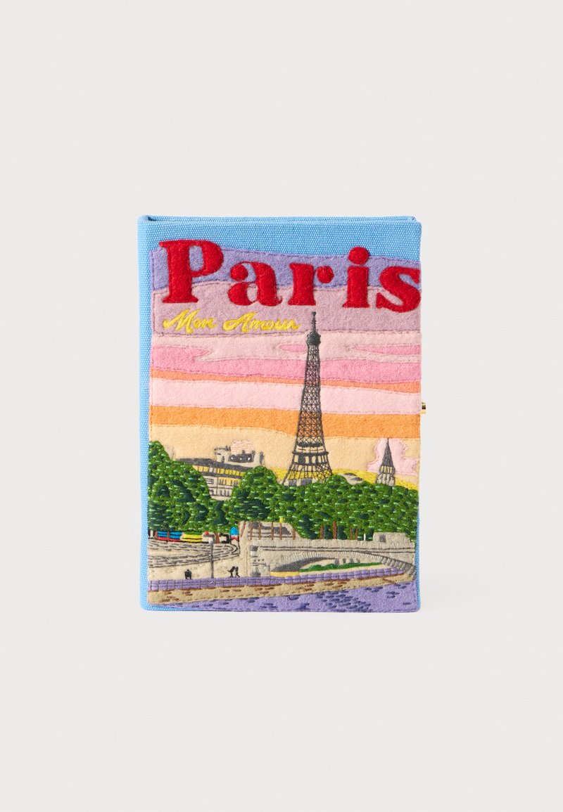 Capa bordada com um horizonte de Paris, incluindo a Torre Eiffel, em cores vibrantes. O texto diz "Paris" e "Mon Amour", sobre um fundo azul claro.