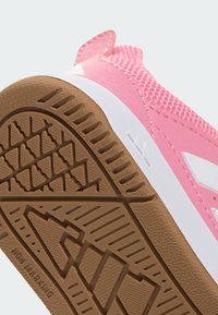 Ružová športová obuv s textúrovaným sieťovinovým zvrškom, bielou medzipodrážkou a hnedou gumovou vonkajšou podrážkou so vzorom geometrického gripu.