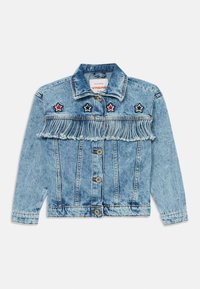 Lyseblå denimjakke med frynser på brystet, tre stjernedekorasjoner i rødt og svart, samt klassisk knappelukking.