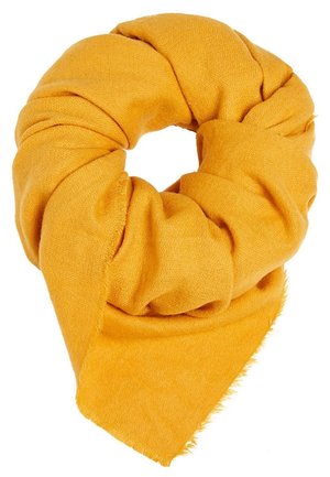 Miękki szal w kolorze musztardowej żółci, złożony w luźny, okrągły węzeł z widocznym spiczastym końcem na białym tle.