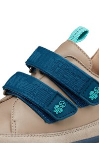 Tan leather shoe with teal fabric straps and octopus-shaped accents. Includes a textured strap with woven detailing and a pull tab.