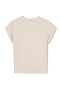 Camiseta corta beige de algodón. Presenta mangas cortas y un escote redondo con ribete cosido. Textura suave, diseño liso.