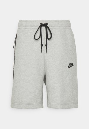 Grå Nike-shorts med snøring i livet, sidelommer med glidelås og svart logodetalj. Laget av mykt, teksturert stoff.