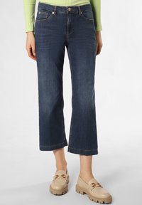 Dark blue cropped jeans with a straight leg, featuring front pockets and a classic button closure. Worn with beige loafers.