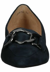 Chaussure plate en daim noir à bout pointu avec un grand ornement chaîne métallique noire brillante et une doublure intérieure couleur fauve.