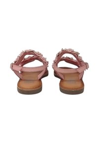 Sandali piatti rosa con volant decorativi lungo le cinghie, fibbia regolabile alla caviglia e una suola interna beige liscia. Suola in gomma.
