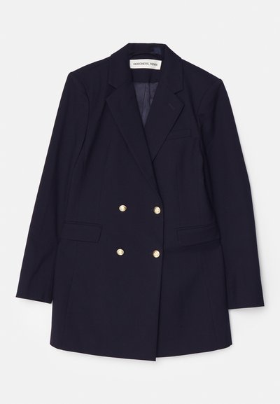 Granatowa marynarka podwójnie zapięta z złotymi guzikami, z szpiczastymi klapami, dwiema przednimi kieszeniami oraz dopasowanym krojem. Gładki materiał, klasyczny design.