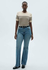 Beige striped short-sleeve sweater, light blue flared jeans, black belt, and black shoes with chain accents. Simple and casual outfit.